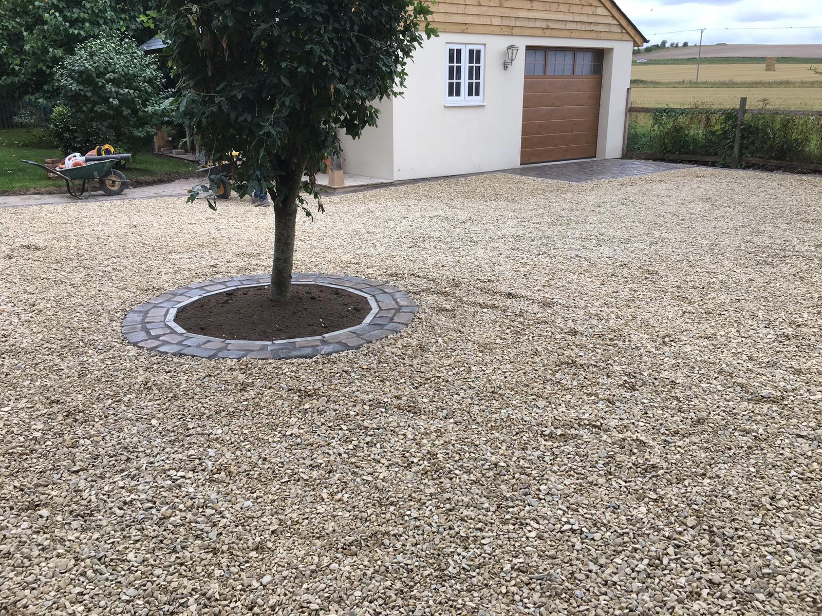 Gravel driveway with cobble tree ring